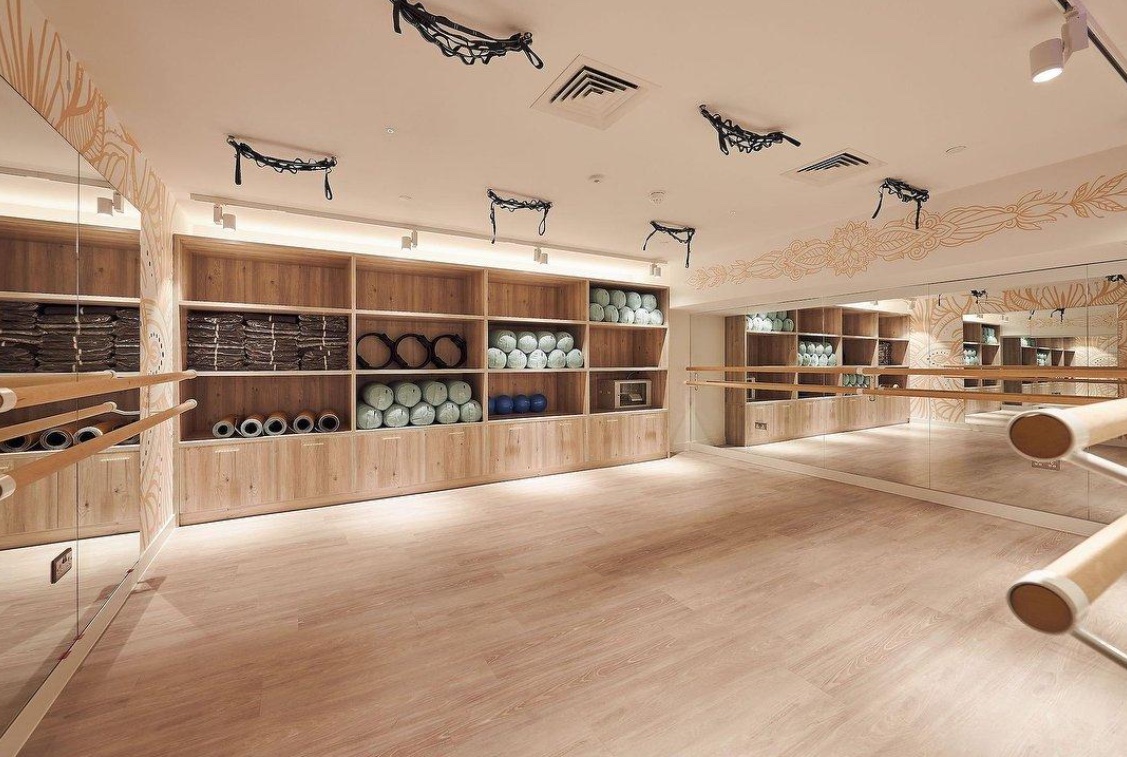 Dance studio with a timber-look sprung floor, mirrored walls and a ballet barre